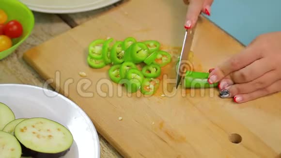 女人用一把刀在木板上切出青长辣椒时间跨度视频的预览图
