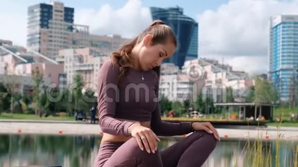 年轻女子坐在瑜伽姿势与城市的背景放松和自由的概念视频的预览图