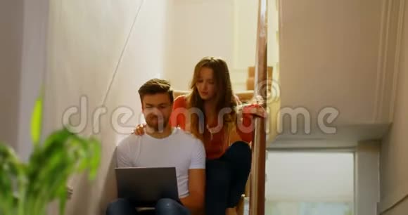 一对夫妇在4k楼梯上讨论笔记本电脑视频的预览图