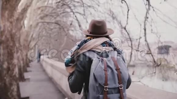 后景的女游客带着背包走在惊人的平面树河岸在寒冷的深秋缓慢的运动视频的预览图