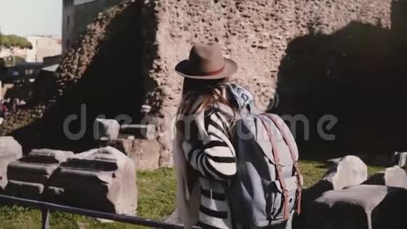 令人兴奋的年轻女游客带着背包戴着时尚的帽子探索罗马论坛微笑着环顾四周视频的预览图