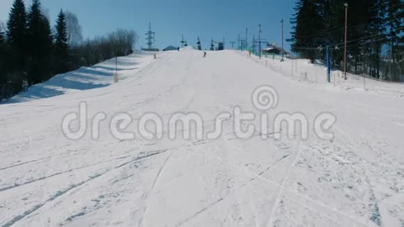 12岁的少年穿着蓝色西装从下一天的雪下滑到滑雪板上从远处看视频的预览图