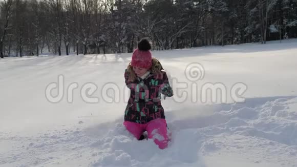 快乐的女人在冬天把雪扔上来坐在雪地里视频的预览图