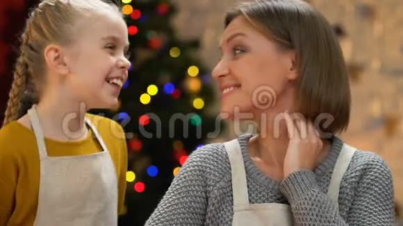 可爱的女儿拥抱母亲一起享受圣诞假期特写镜头视频的预览图