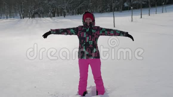 快乐的女人举起双臂在冬天的大雪中仰面倒下视频的预览图