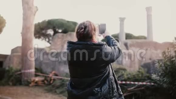 兴奋的高级微笑欧洲妇女在意大利奥斯蒂亚的古柱遗址拍照度假之旅视频的预览图