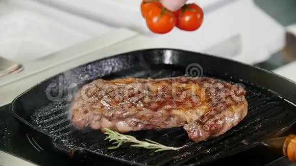 餐厅厨房厨师煎一块牛排然后把樱桃番茄放进锅里视频的预览图