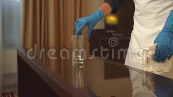 旅馆房间里戴手套的胡塞梅德用抹布擦桌子视频的预览图