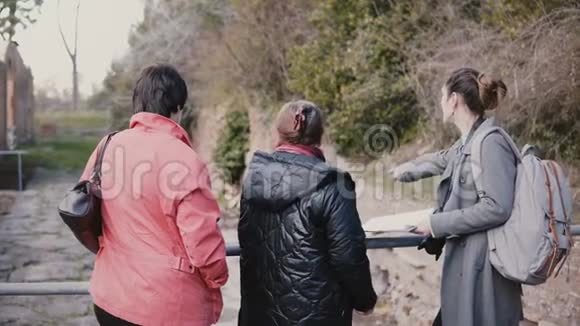 年轻美丽的欧洲女导游为意大利奥斯蒂亚的两位老年妇女提供了一次步行之旅视频的预览图