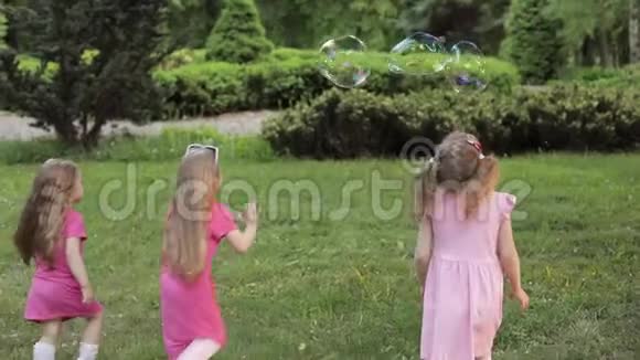 快乐的小女孩在花园里玩泡泡视频的预览图