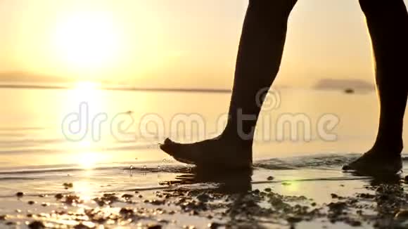 妇女在日落或日出时沿海滩行走的腿视频的预览图
