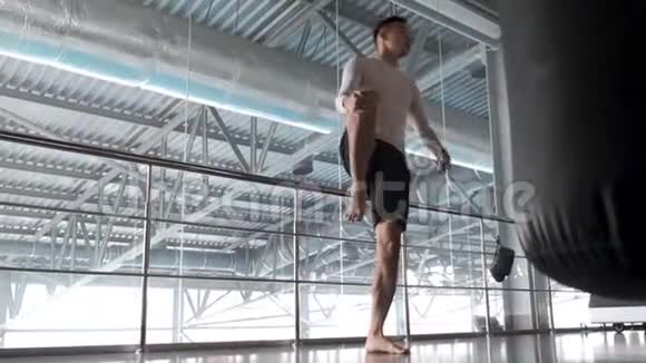 一个年轻的亚洲人正在跆拳道健身房训练热身视频的预览图