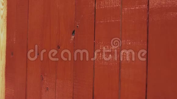 画家用棕色或红色的醇酸漆画一堵墙或木条栅栏视频的预览图