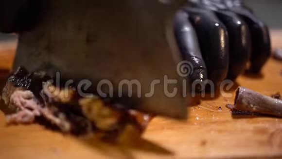 厨师把刚煮好的多汁的香煎排骨切碎在优雅的木桌上慢动作关闭视频的预览图