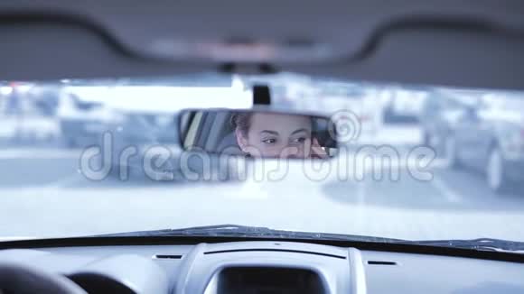 布鲁内特女士在开车时用手机说话通过后视镜的后视镜视频的预览图