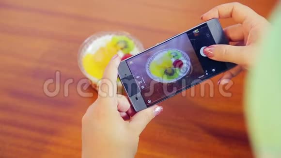女性手拿着手机拍蛋糕视频的预览图
