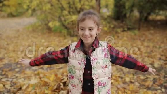 小女孩高兴地掉进了一大堆黄色的叶子里视频的预览图
