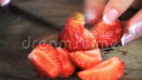 双手合拢切下新鲜的大草莓供以后使用视频的预览图