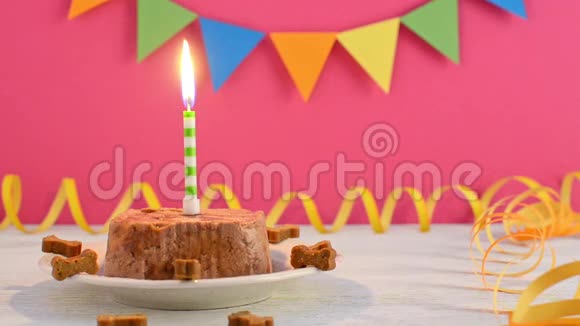 狗的生日快乐蛋糕由湿食物和蜡烛在粉红色的聚会背景视频的预览图