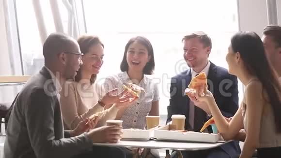 快乐的多元文化商业团队在办公室谈笑风生地吃披萨视频的预览图