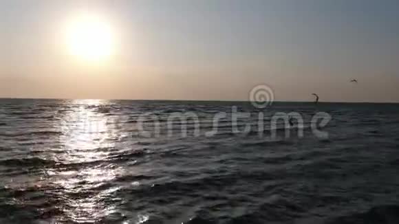 空中拍摄一名男子在海面上风筝水面上太阳的倒影视频的预览图