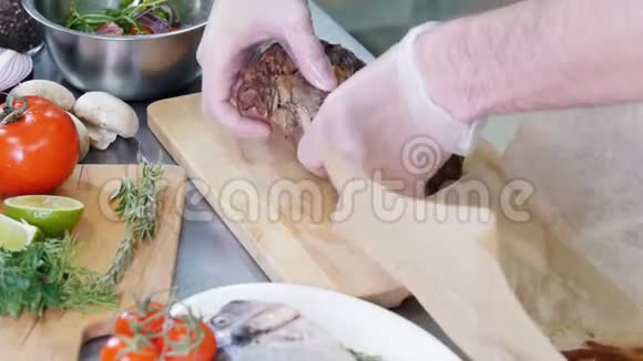 在厨房工作的厨师厨师把煎牛排放在切割板上视频的预览图