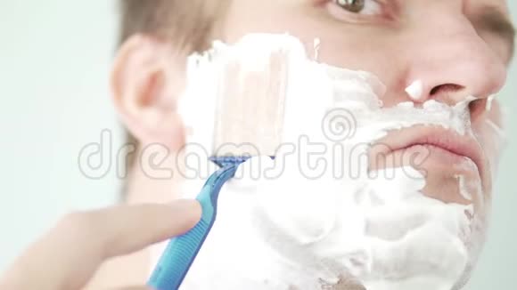 一个男人用蓝色剃刀刮脸视频的预览图