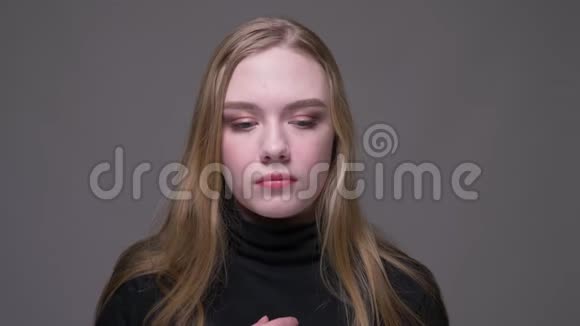 年轻漂亮的黑发女性的特写镜头她的喉咙不舒服背景与灰色隔离视频的预览图