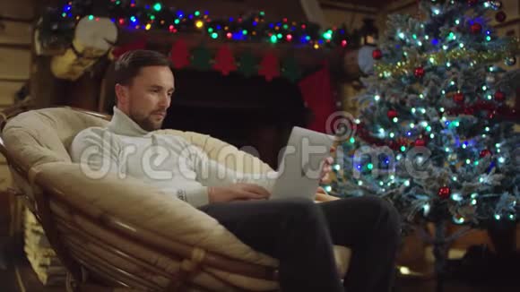成年男子在圣诞夜使用笔记本电脑在社交网络上发短信视频的预览图