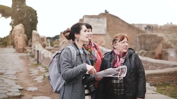 年轻的高加索女游客导游向两位高级女游客详细介绍意大利奥斯蒂亚的历史遗迹视频的预览图