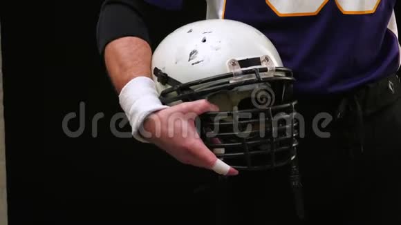 美式足球美国足球运动员双手拿着头盔双手手持头盔特写美国视频的预览图