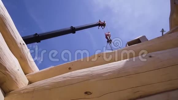 用木吊车并在施工现场作业剪辑木建筑施工过程的底视图视频的预览图