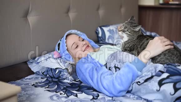 一个猫躺在床上被毯子覆盖的女孩视频的预览图
