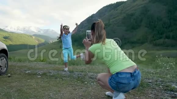 女孩很高兴冲向妈妈脖子女人和孩子拥抱和旋转慢动作4k60fps山区视频的预览图