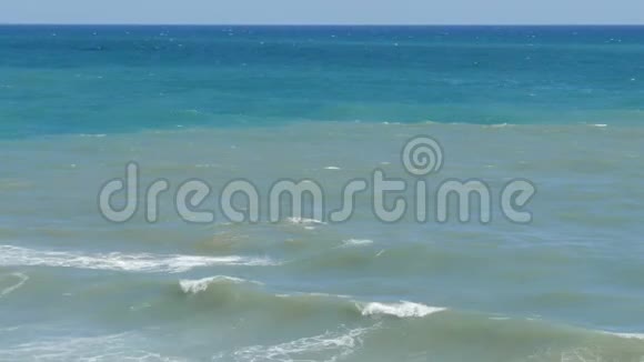 美丽的三色海有不同色调的蓝绿色和深绿色上面有波浪和白色泡沫视频的预览图