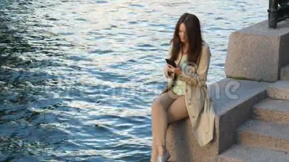 拥有智能手机的女性可以欣赏城市和河景视频的预览图