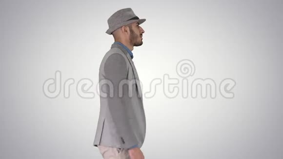 穿帽子的随便阿拉伯男人在渐变背景下行走视频的预览图