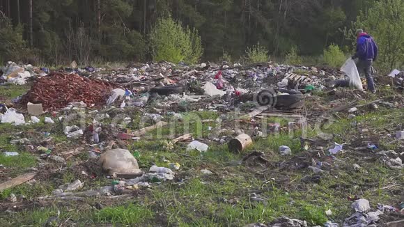 无家可归的人寻找有用的物品和食物以生存之间的垃圾垃圾堆环境视频的预览图