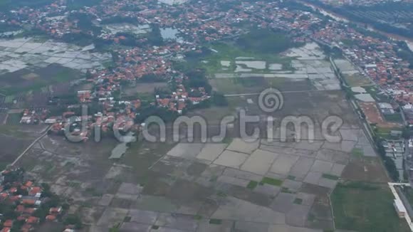 从飞机窗口可以看到巴厘岛的田野和村庄印度尼西亚视频的预览图