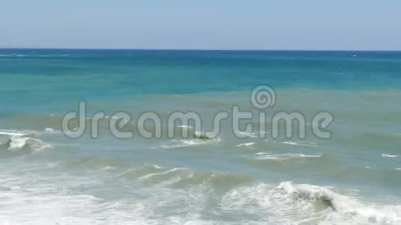 美丽的三色海有不同色调的蓝绿色和深绿色上面有波浪和白色泡沫视频的预览图