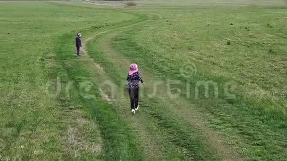 一个男孩和一个女孩在田野里跑来跑去视频的预览图