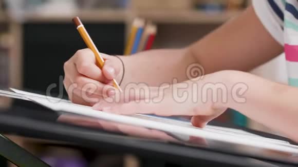女孩用铅笔在一张纸上画东西视频的预览图