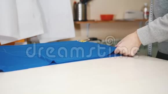 服装厂的工人整齐地把一块蓝色的布放在桌子上视频的预览图