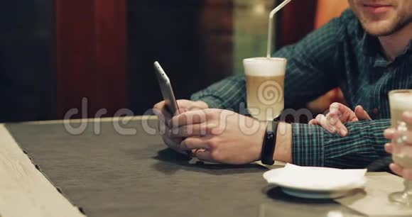 有胡子的年轻人在咖啡馆里用手机视频的预览图