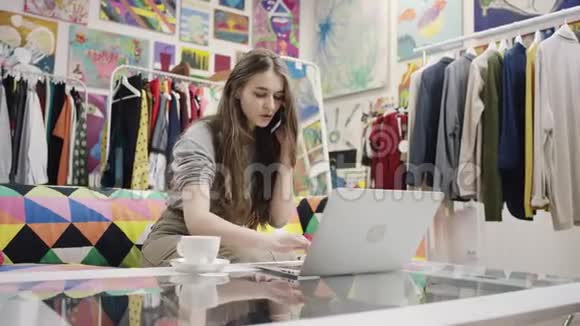 年轻女性在笔记本电脑上工作在智能手机上聊天视频的预览图