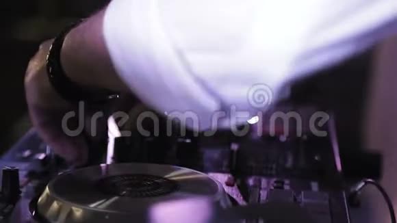 DJ在转盘音乐设备上播放音乐混合和刮擦配有灯光和控制的专业音乐设备视频的预览图