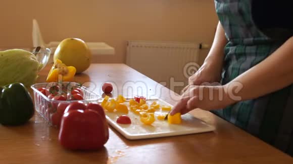 妈妈在厨房准备一份蔬菜沙拉小女儿跑过来抓了一个西红柿幸福家庭视频的预览图