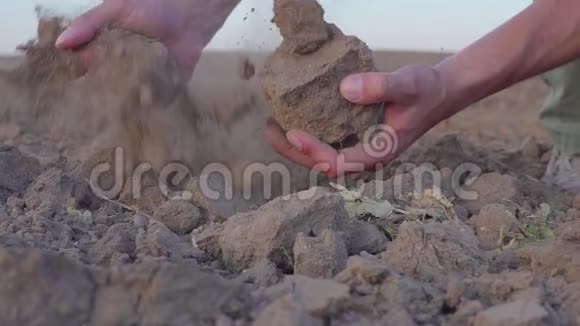 人类手握土尘的慢动作视频干旱无雨的土地视频的预览图