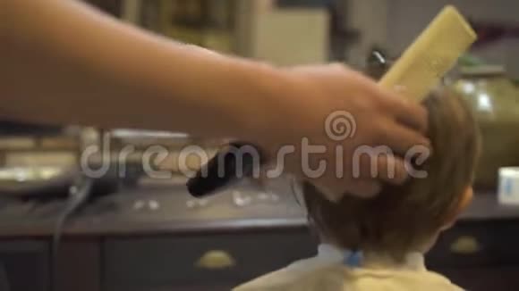 理发店用电动剃须刀剪孩子头发孩子们在沙龙剪发带电动的男生发型视频的预览图