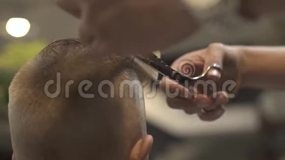发型师用理发剪剪头发并在美发沙龙里梳头儿童理发视频的预览图